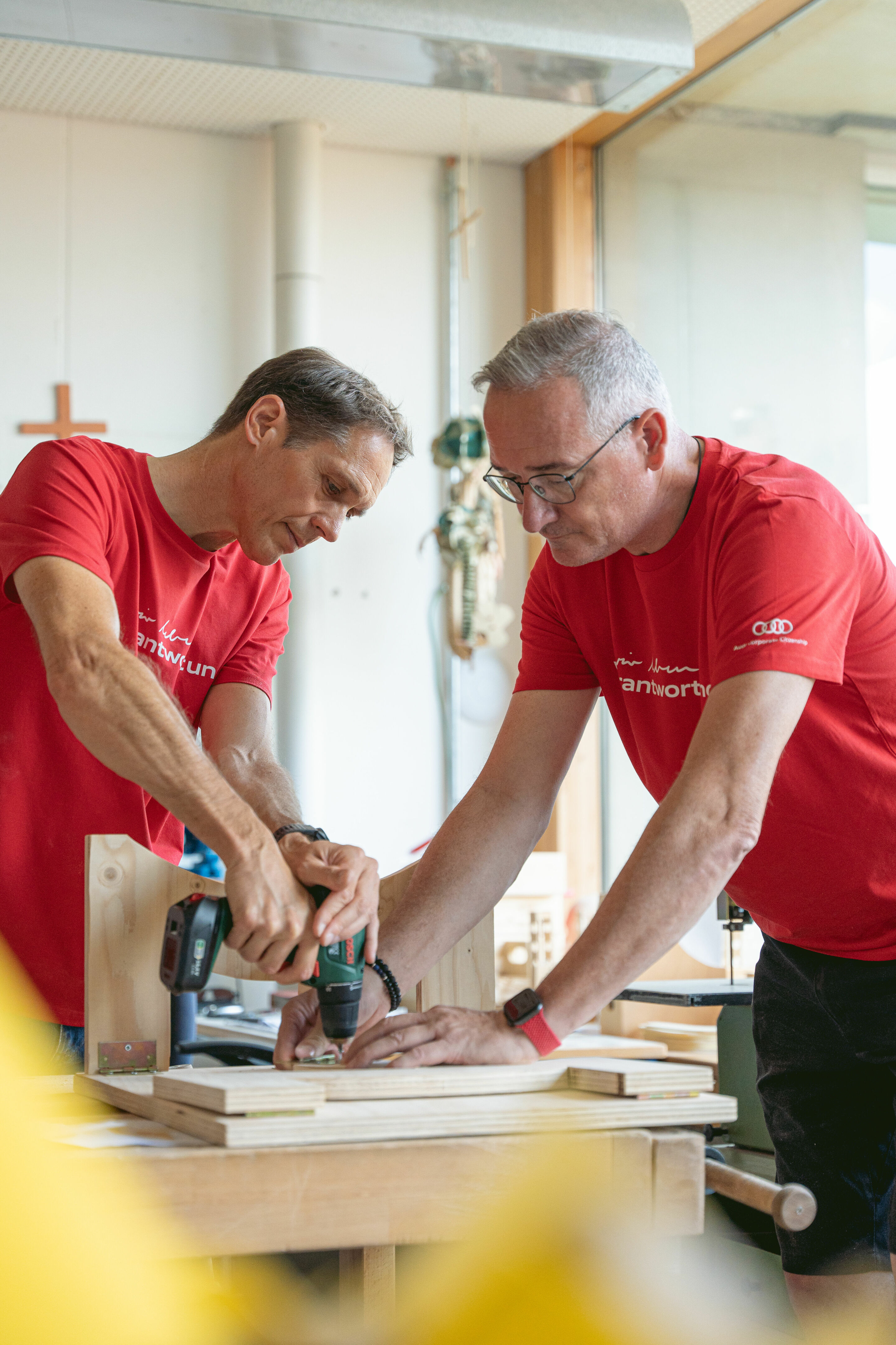 Audi Social Day - Am 24. Juni 2023 sind Audianer_innen für verschiedene soziale Organisationen im Einsatz. Im Bild: Projekt „Klapptische bauen für die Kinderkrippe Hollerstauden“, Ingolstadt. Mit am Start: Audi-Produktionsvorstand Gerd Walker und Andreas...