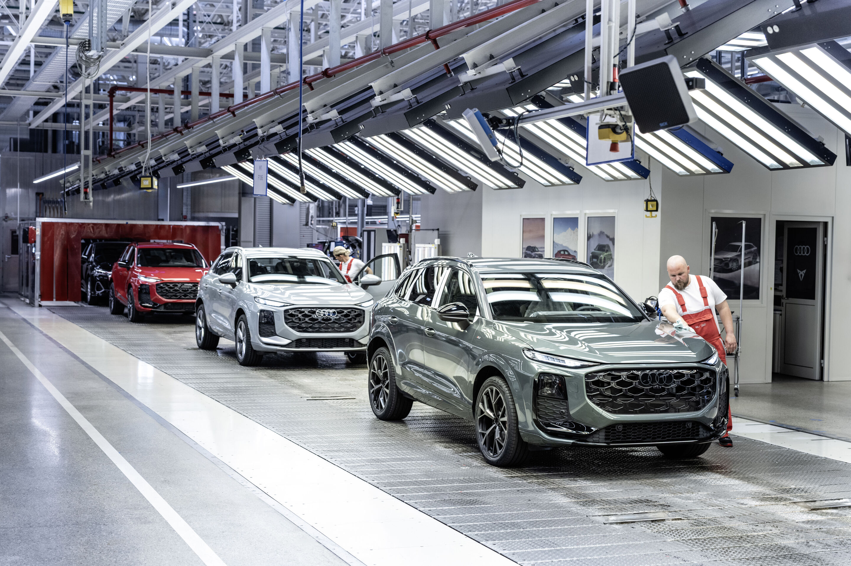 Audi Q3 SUV - Der Audi Q3 wird bei Audi Hungaria in Győr gefertigt. Im Bild: Fahrzeugmontage, Finish und Oberflächenprüfung, Farbe, v.l.n.r.: Progressivrot metallic, Pfeilgrau Perleffekt, Salbeigrün metallic