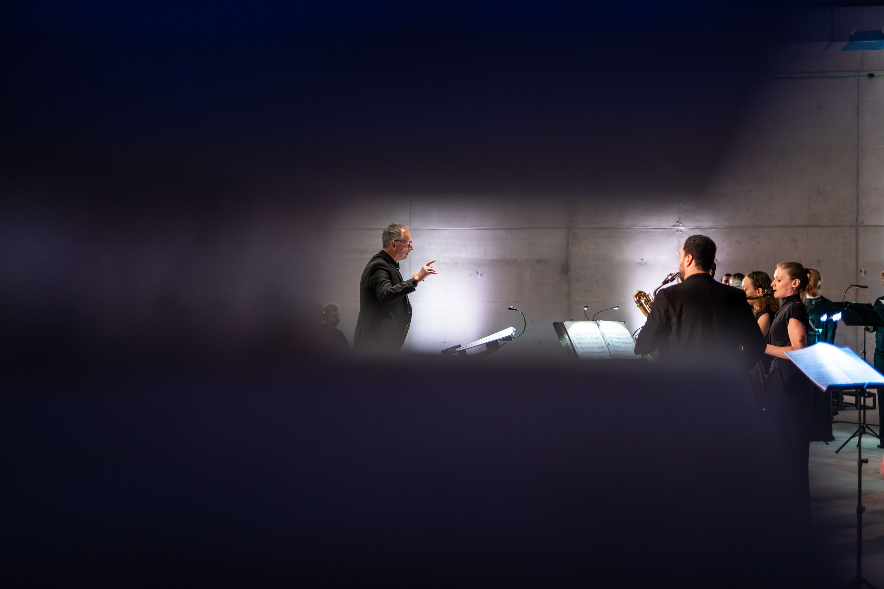 “Lux!”: Theatrical concert at the construction site of the MCAD; Arcis Saxophone Quartet, vocal ensemble LauschWerk - On the construction site of the new Museum of Concrete Art and Design Ingolstadt, the side view of the staged concert “Lux!” shows conductor...