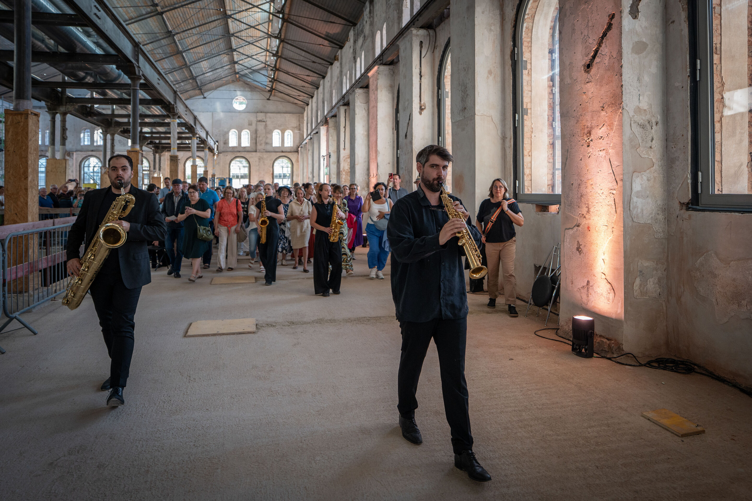 „Lux!“: Inszeniertes Konzert auf der Baustelle des MKKD; Arcis Saxophon Quartett, Vokalensemble LauschWerk - Jure Knez, Claus Hierluksch, Ricarda Fuss und Anna-Marie Schäfer vom Arcis Saxophon Quartett laufen beim inszenierten Konzert „Lux!“ über die...