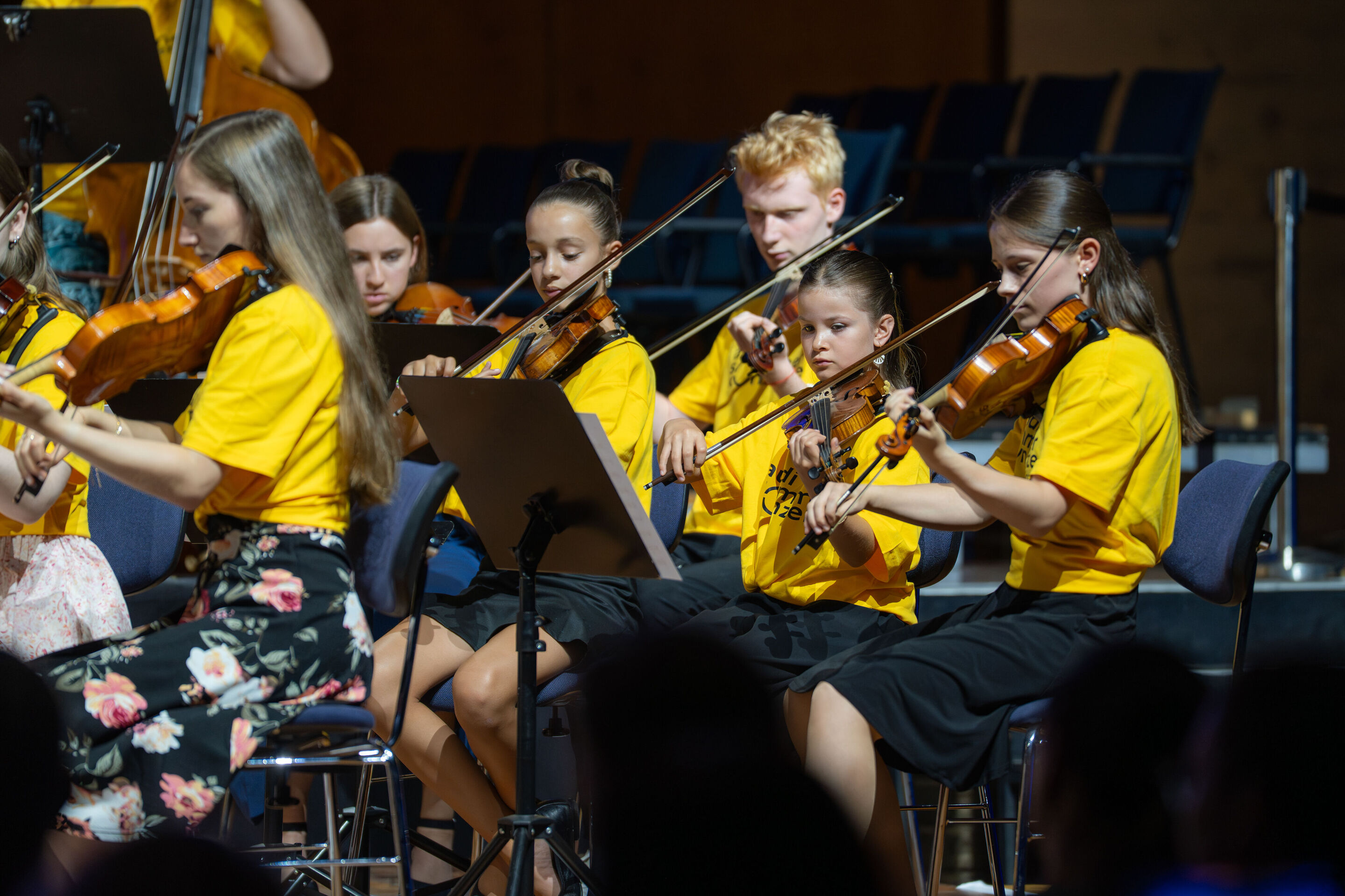 Öffentlicher Workshop mit Schülerinnen und Schülern der Region und dem Aurora Orchestra - Auf der Bühne des Festsaals Ingolstadt musiziert eine Gruppe Schülerinnen und Schüler auf ihren Streichinstrumenten.
