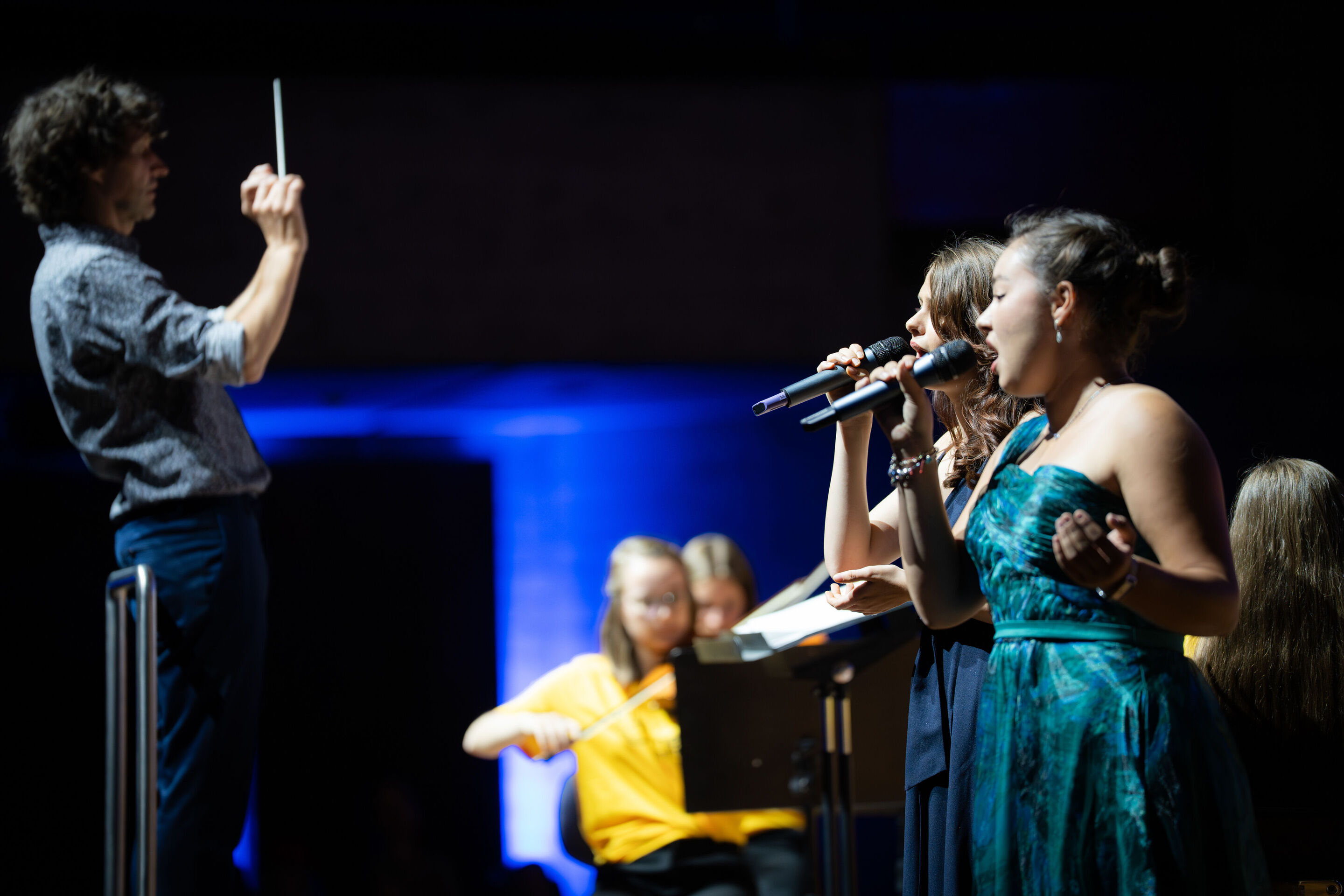Öffentlicher Workshop mit Schülerinnen und Schülern der Region und dem Aurora Orchestra - Die Solistinnen Sarah Seyfert und Miriam Werner (Schülerinnen,11. Klasse, Gnadenthal-Gymnasium) singen auf der Bühne des Festsaals Ingolstadt. Links ist unscharf...