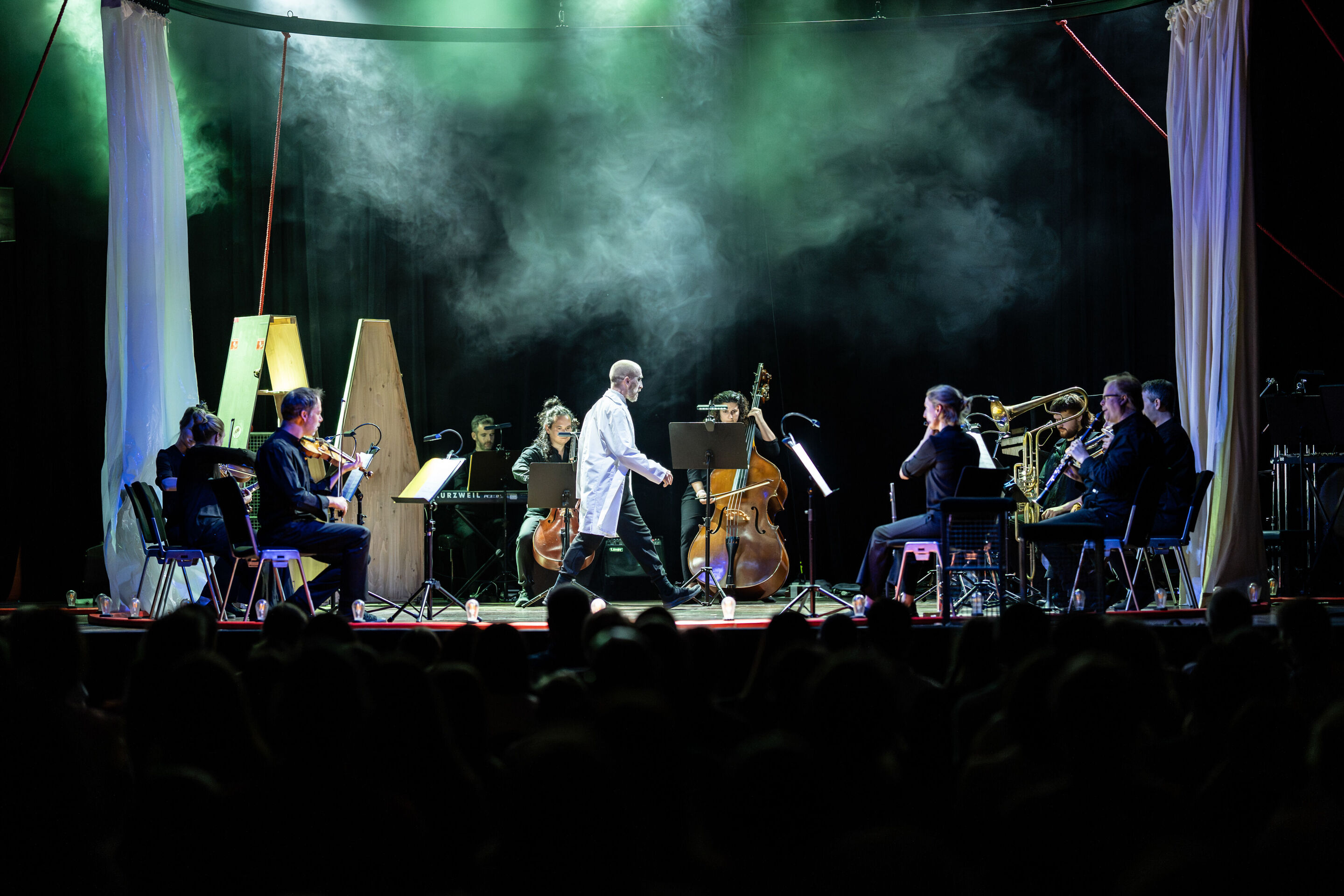 “Carnival”: Theatrical concert for families about the fabulous world of instruments - On the stage of the Festival Hall Ingolstadt, members of the Aurora Orchestra are arranged in a circle, playing their instruments. In the center, dancer Christopher...