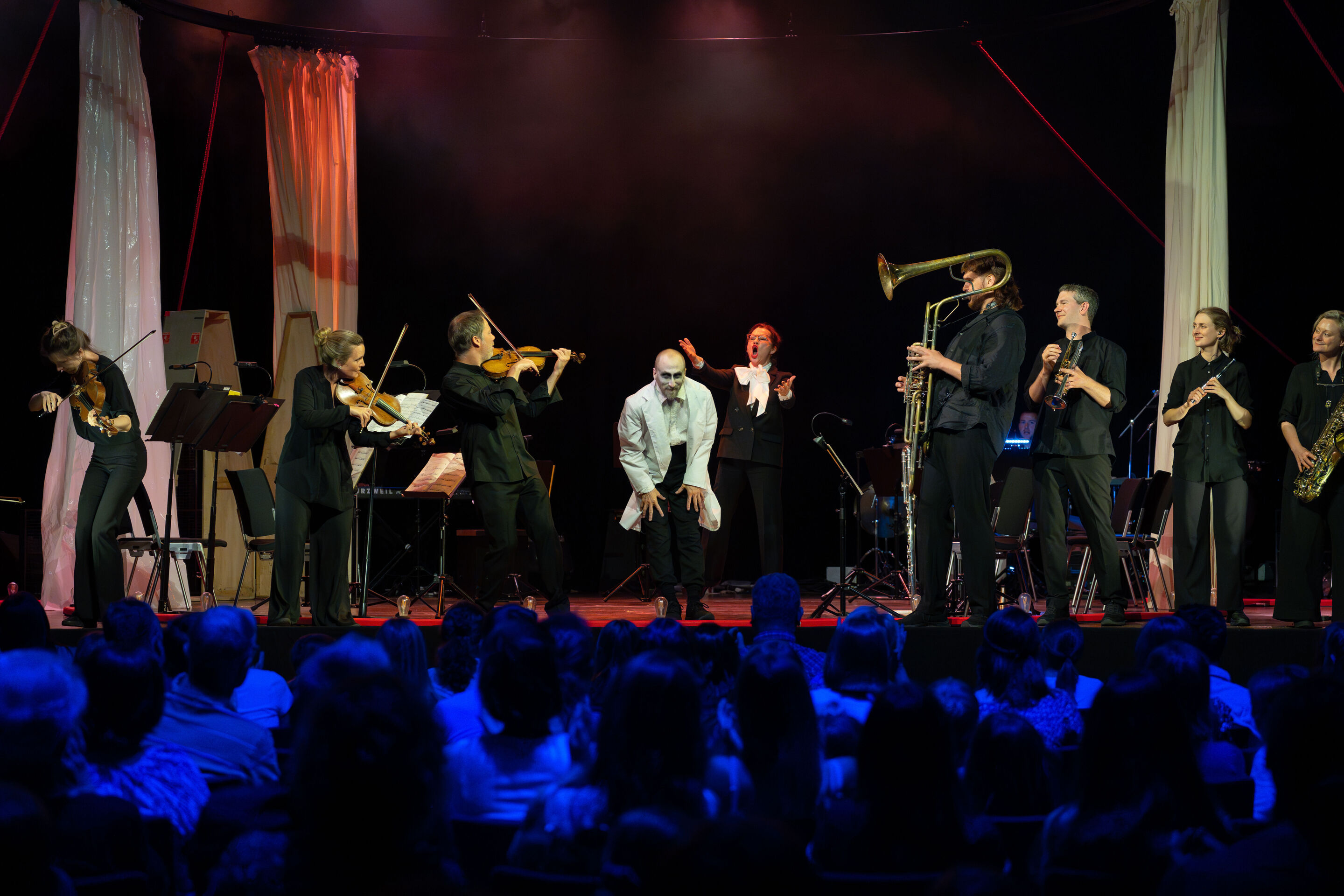 “Carnival”: Theatrical concert for families about the fabulous world of instruments - From the audience's perspective, dancer Christopher Akrill bows on the stage of the Festival Hall Ingolstadt, framed by musicians of the Aurora Orchestra. Behind him,...