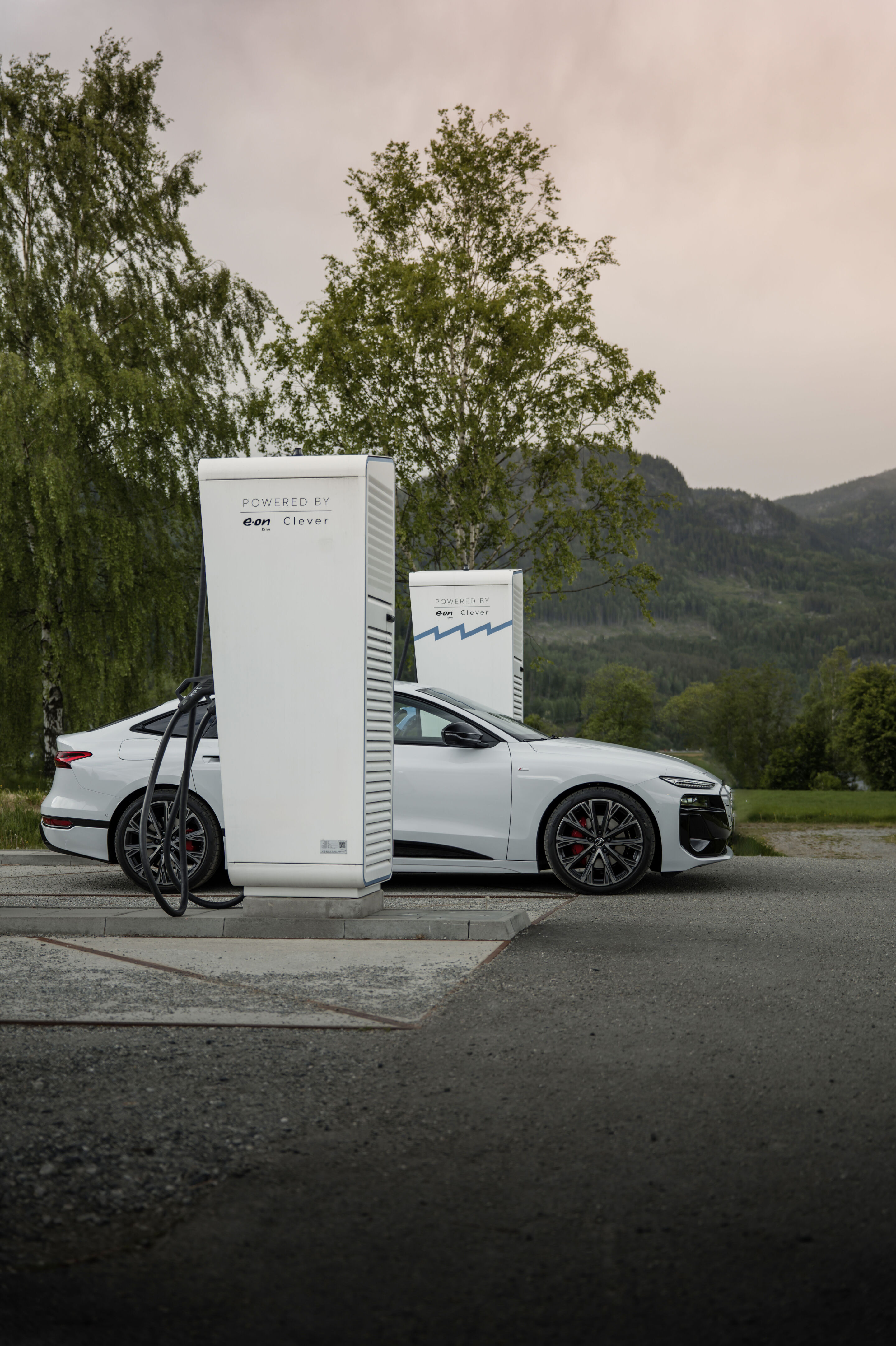 All charged up: from Copenhagen to Bergen in the A6 e-tron - An Audi A6 Sportback e-tron in Glacier white metallic charges while parked between two charging points.