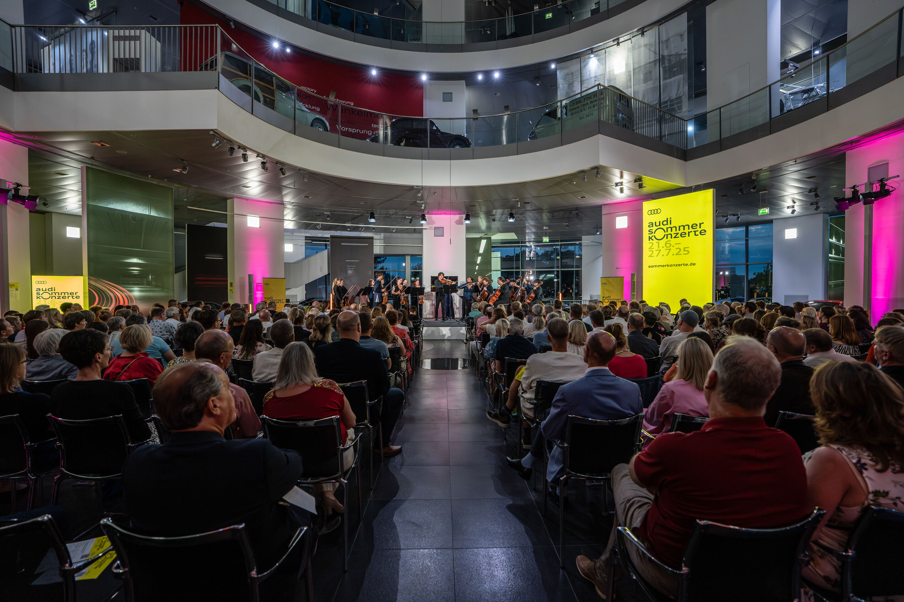 “Crossing over the Atlantic”: from Britten to Nirvana with the O/Modernt chamber orchestra - From the audience’s perspective, the O/Modernt Chamber Orchestra, conducted by Hugo Ticciati, is seen on the stage of the Audi museum mobile.