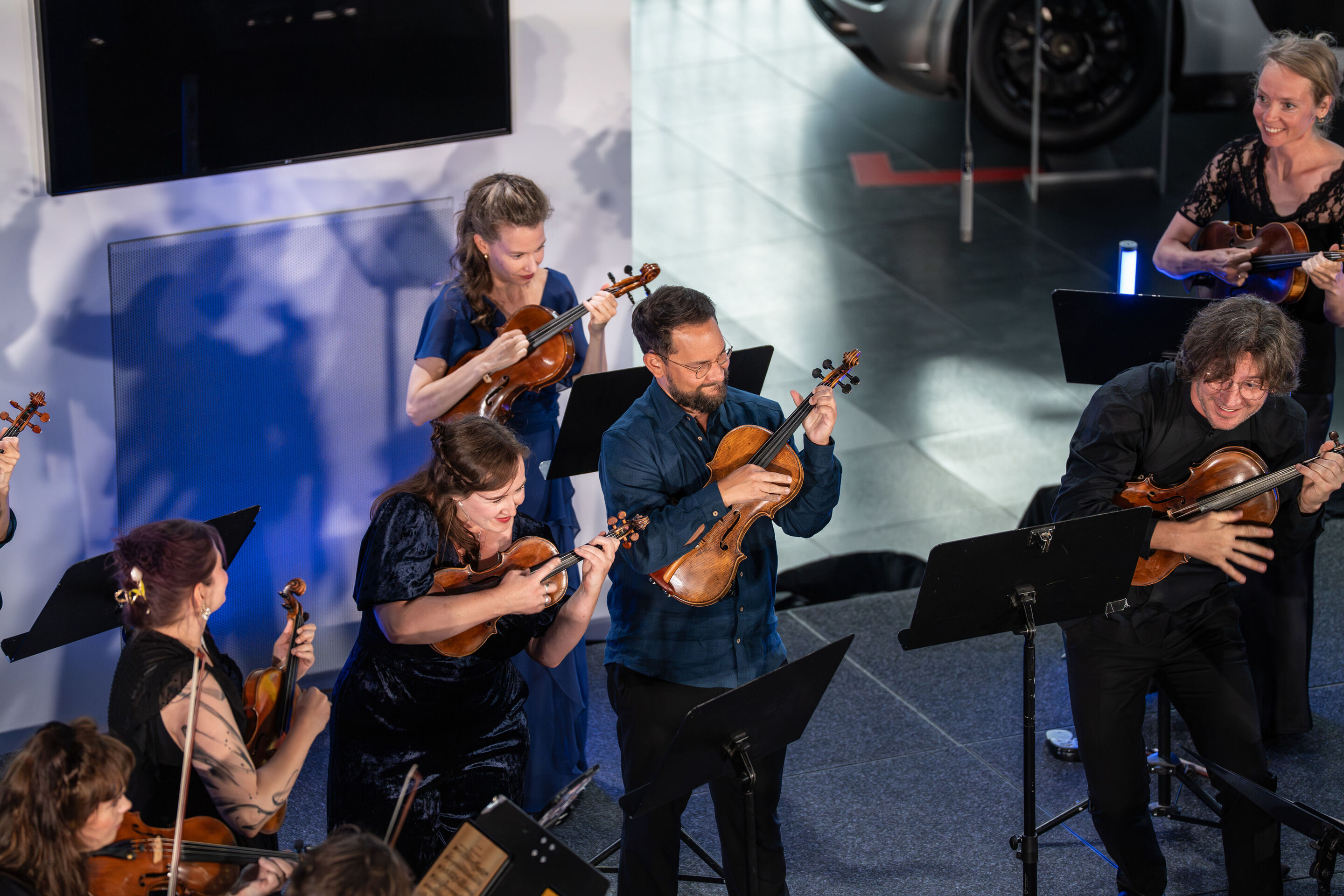 “Crossing over the Atlantic”: from Britten to Nirvana with the O/Modernt chamber orchestra - A portion of the O/Modernt Chamber Orchestra is visible from above on the stage of the Audi museum mobile.
