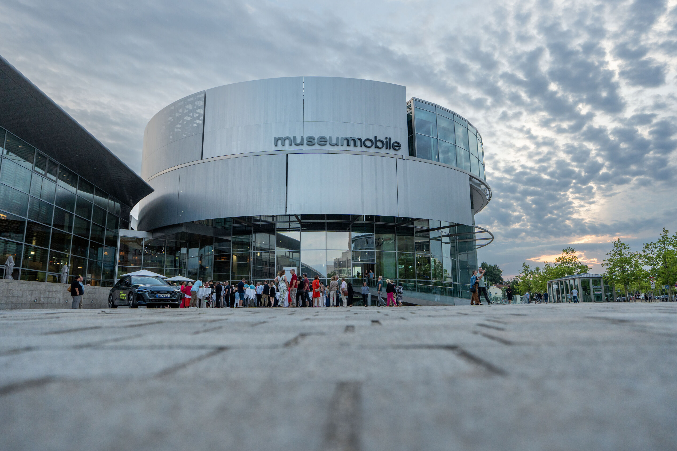 “Crossing over the Atlantic”: from Britten to Nirvana with the O/Modernt chamber orchestra - The Audi museum mobile, with visitors of “Crossing over the Atlantic” standing in front.