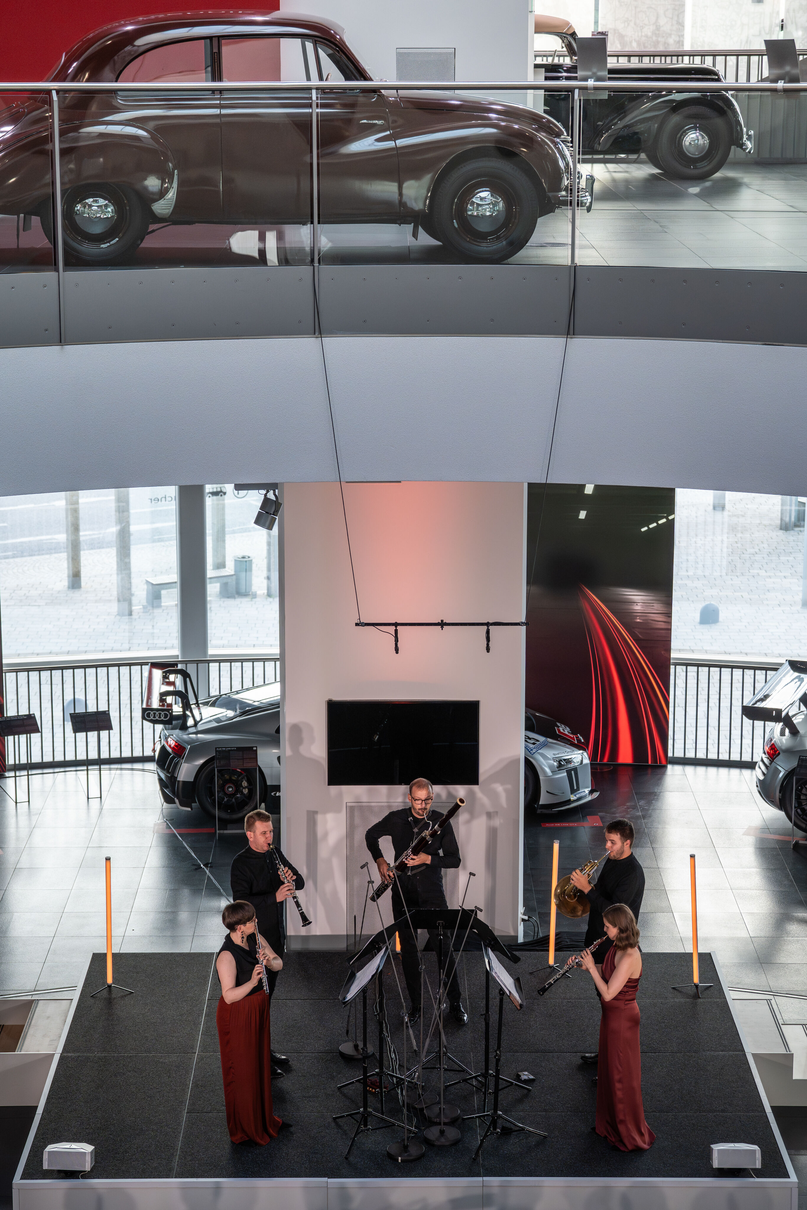 Alinde Quintet – ARD-Musikwettbewerb Preisträger - Von oben: Auf der Bühne des Audi museum mobile musiziert das Alinde Quintet. Oberhalb der Bühne sind historische Fahrzeuge zu sehen.