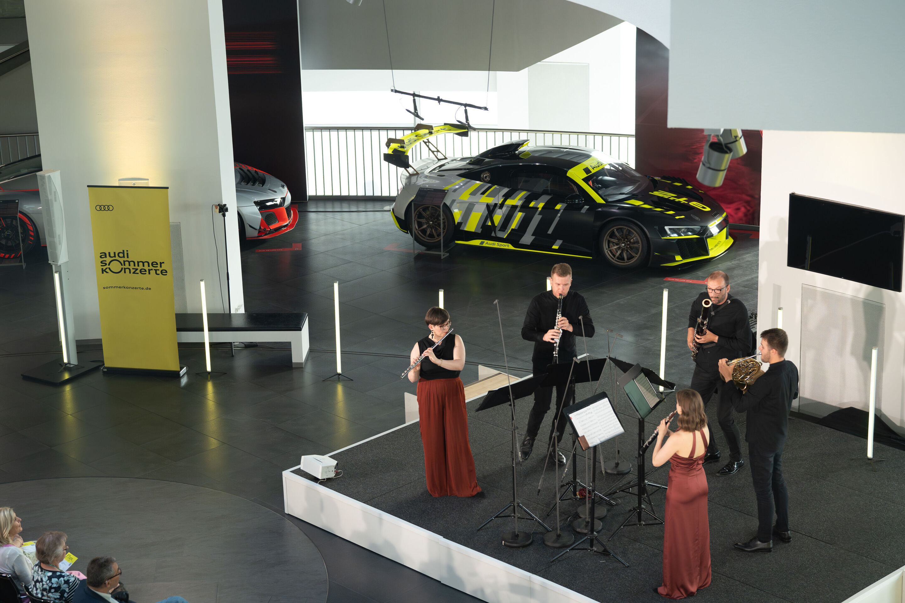 Alinde Quintet – ARD-Musikwettbewerb Preisträger - Auf der Bühne im Audi museum mobile sind die Musizierenden des Alinde Quintets zu sehen. Dahinter links ist ein R8 aus der aktuellen Sonderausstellung.