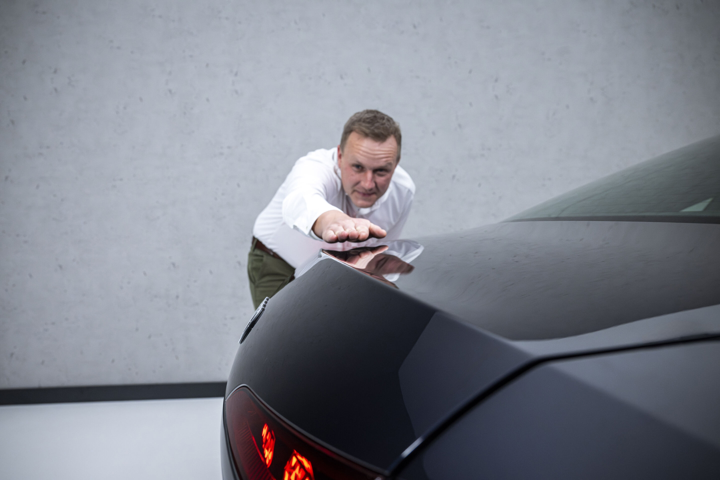 The new A6 Sedan launches across retail locations - Aerodynamics developer Sebastian Weiper (left) points to an edge integrated into the tailgate of the Audi A6 Sedan that creates optimum stall.