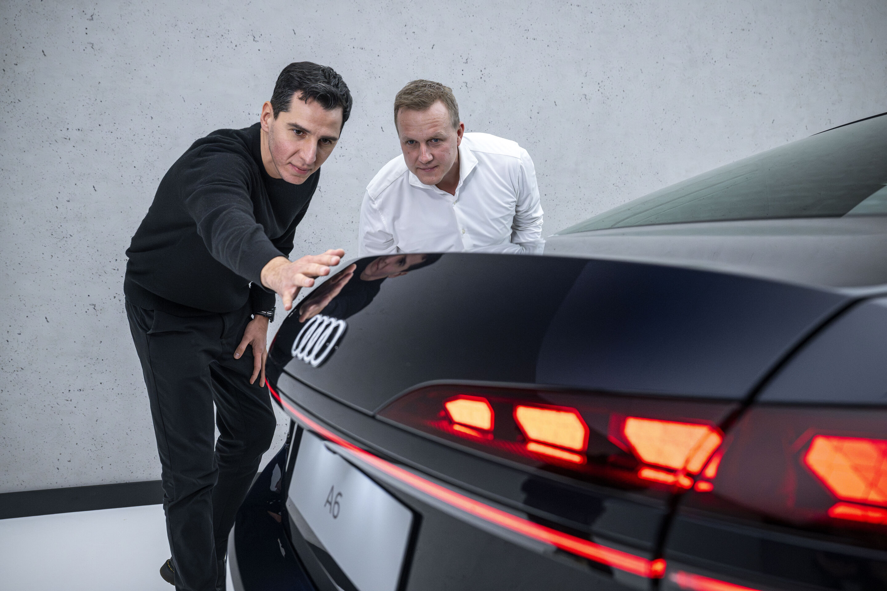The new A6 Sedan launches across retail locations - Exterior designer Francesco d’Amore (left) shows aerodynamics developer Sebastian Weiper (right) an edge integrated into the tailgate of the Audi A6 Sedan that creates optimum stall.