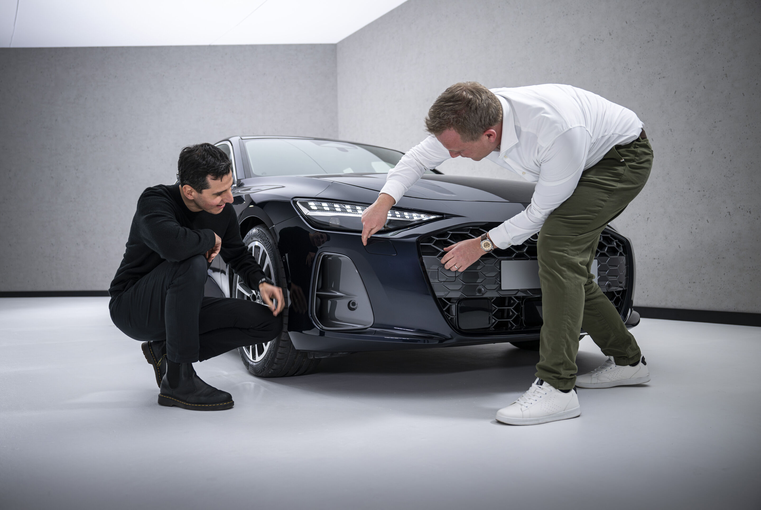 The new A6 Sedan launches across retail locations - Aerodynamics developer Sebastian Weiper (right) shows exterior designer Francesco d’Amore (left) the air curtains on the Audi A6 Sedan.