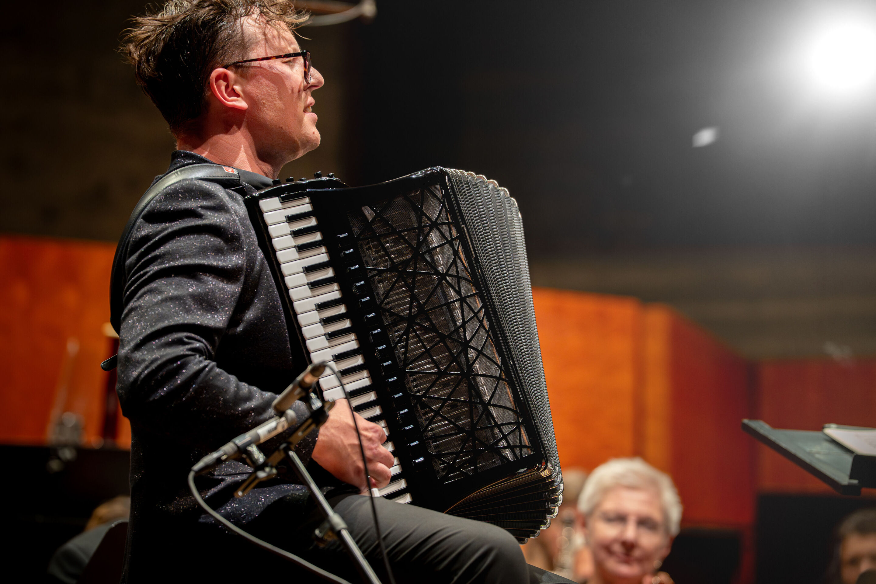 Closing concert with accordion star Martynas Levickis and the Deutsche Kammerphilharmonie Bremen - Close-up of accordion star Martynas Levickis in the middle of the Deutsche Kammerphilharmonie Bremen on the stage of the Festsaal Ingolstadt.