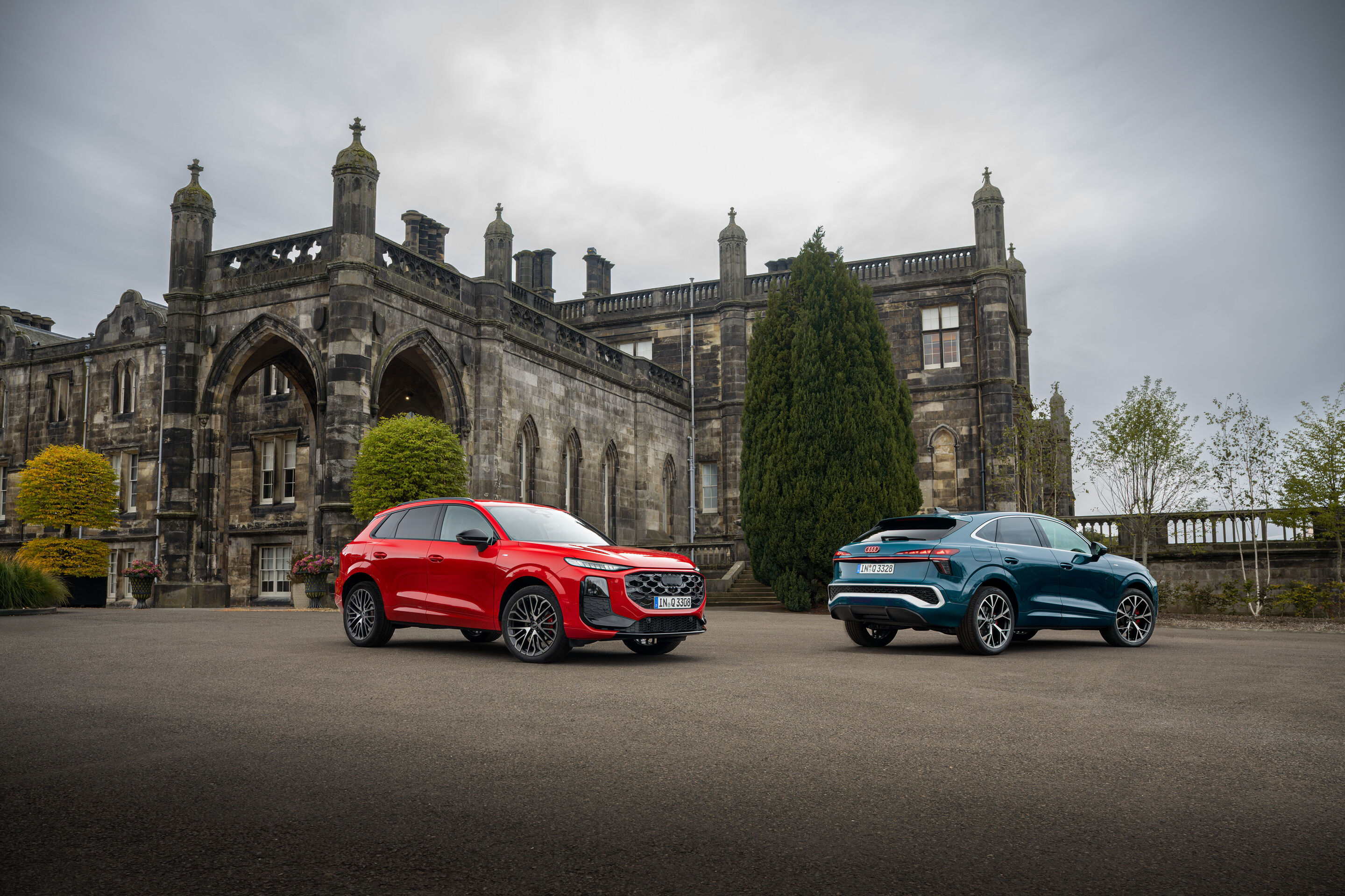 Compact class meets Celtic charm: the new  Audi Q3 in Scotland - Progressive red metallic and Malpelo blue metallic, outdoor static photo, exterior, three-quarter front view and three-quarter rear view