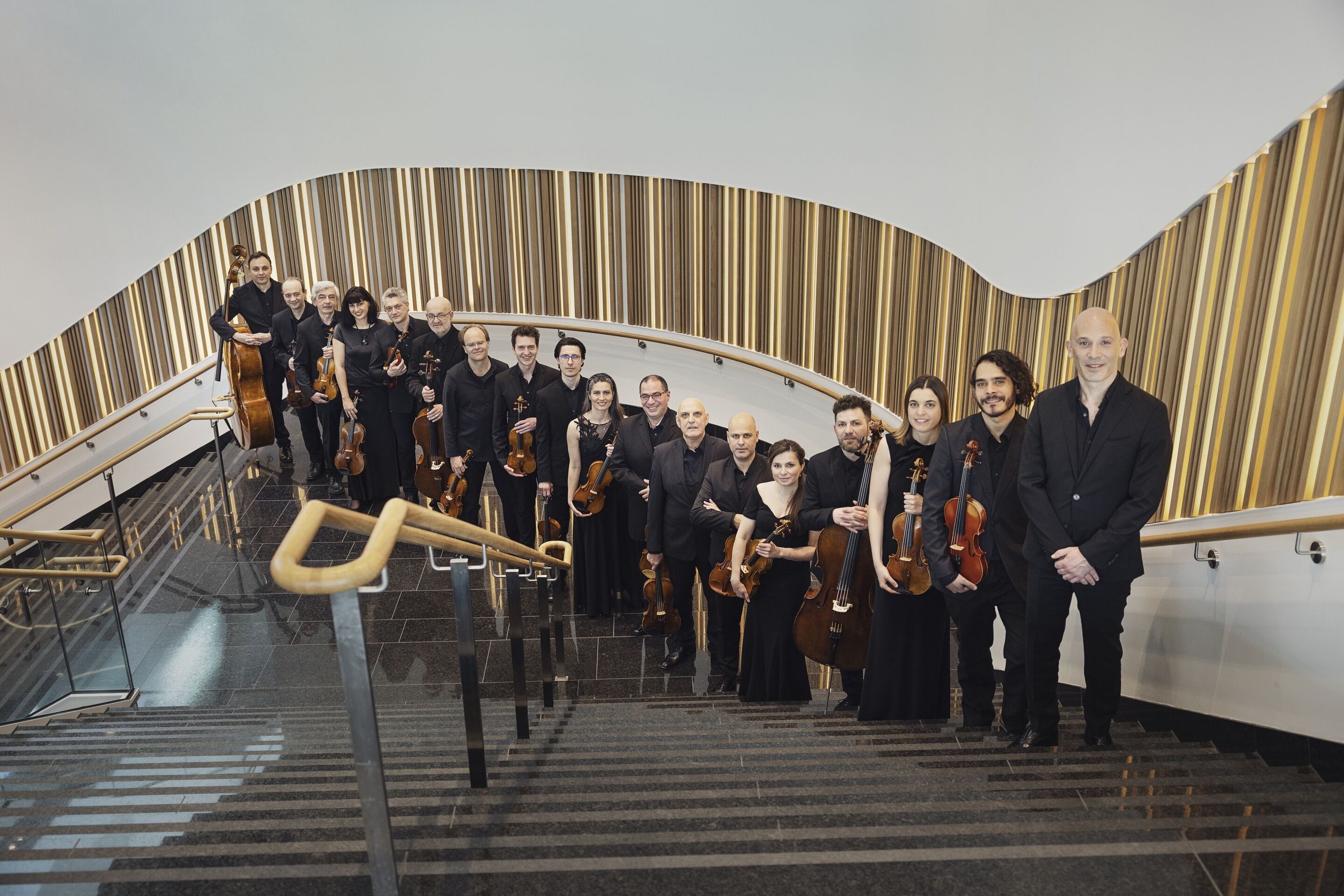 Audi Weihnachtskonzert mit aufstrebenden Solokünstlern - Die Musikerinnen und Musiker der Kammerphilharmonie Ingolstadt stehen aufgereiht auf einer Treppe.