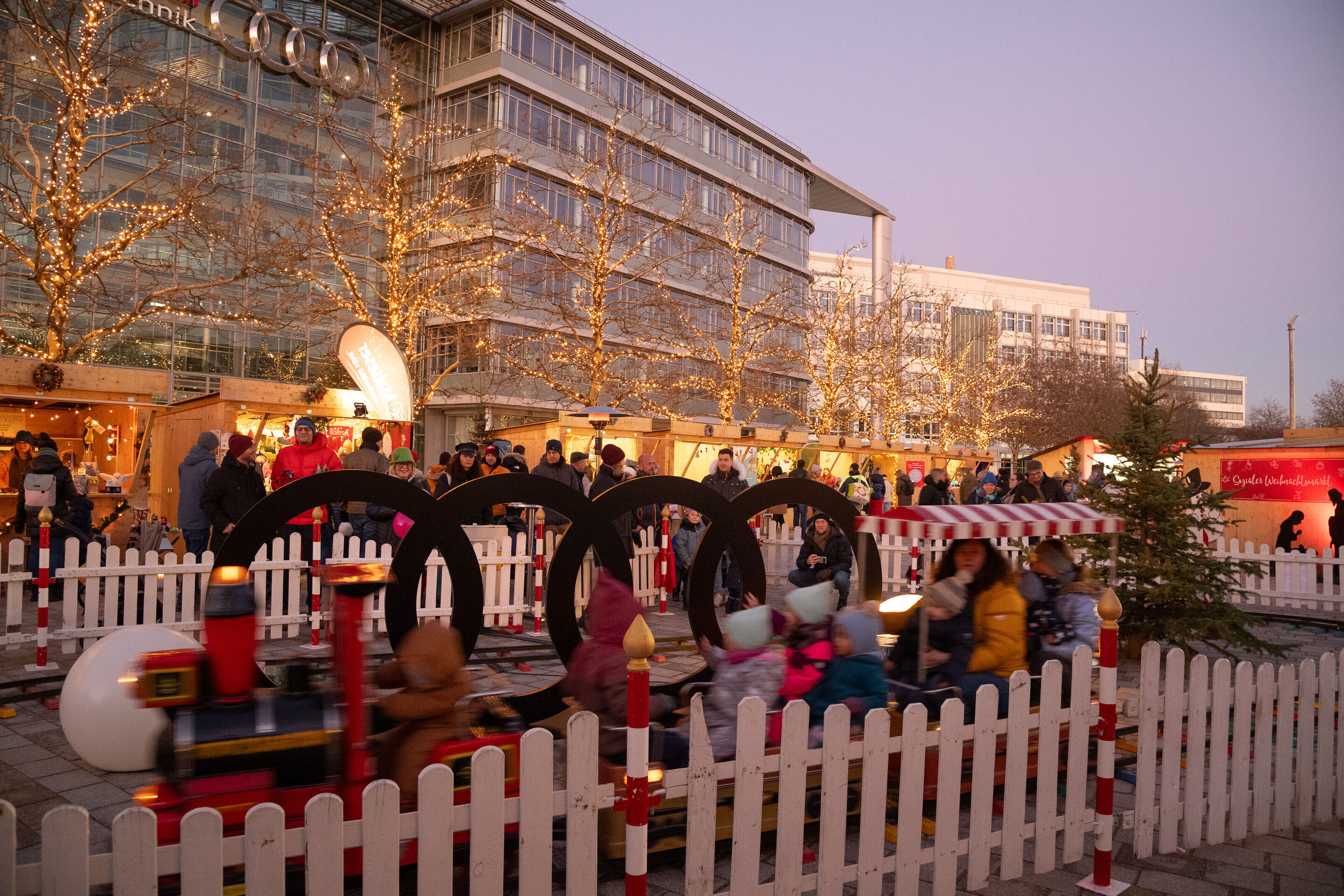Sozialer Weihnachtsmarkt mit spektakulärer Feuershow - Auf der Audi Piazza vor dem Audi Forum Ingolstadt stehen Verkaufsstände aus Holz, die für den Sozialen Weihnachtsmarkt aufgestellt wurden.