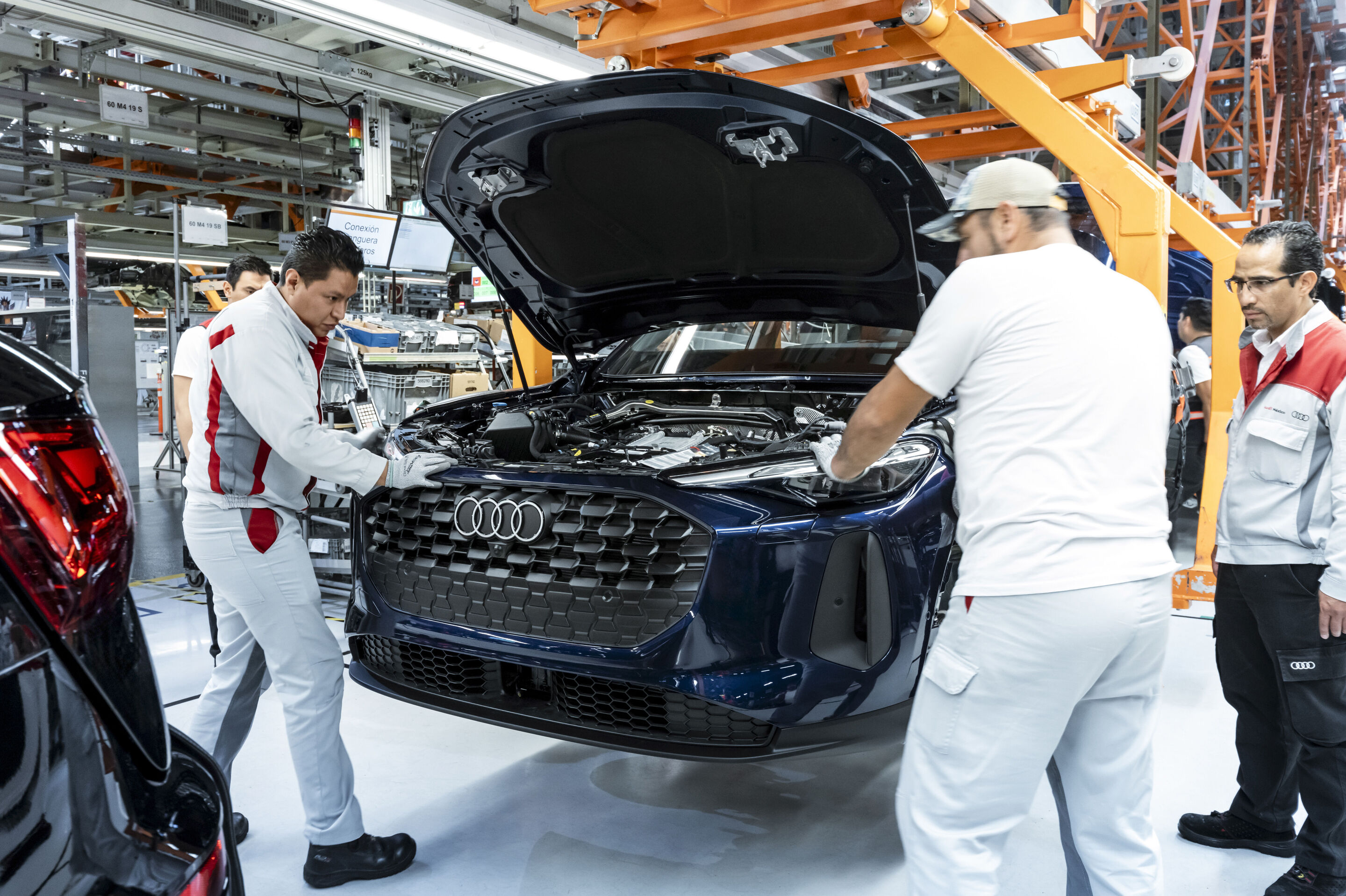 Audi Q5 Produktion am Standort San José Chiapa - Die Scheinwerfer eines neuen Audi Q5 werden von Mitarbeitenden in der Produktion sorgfältig eingepasst