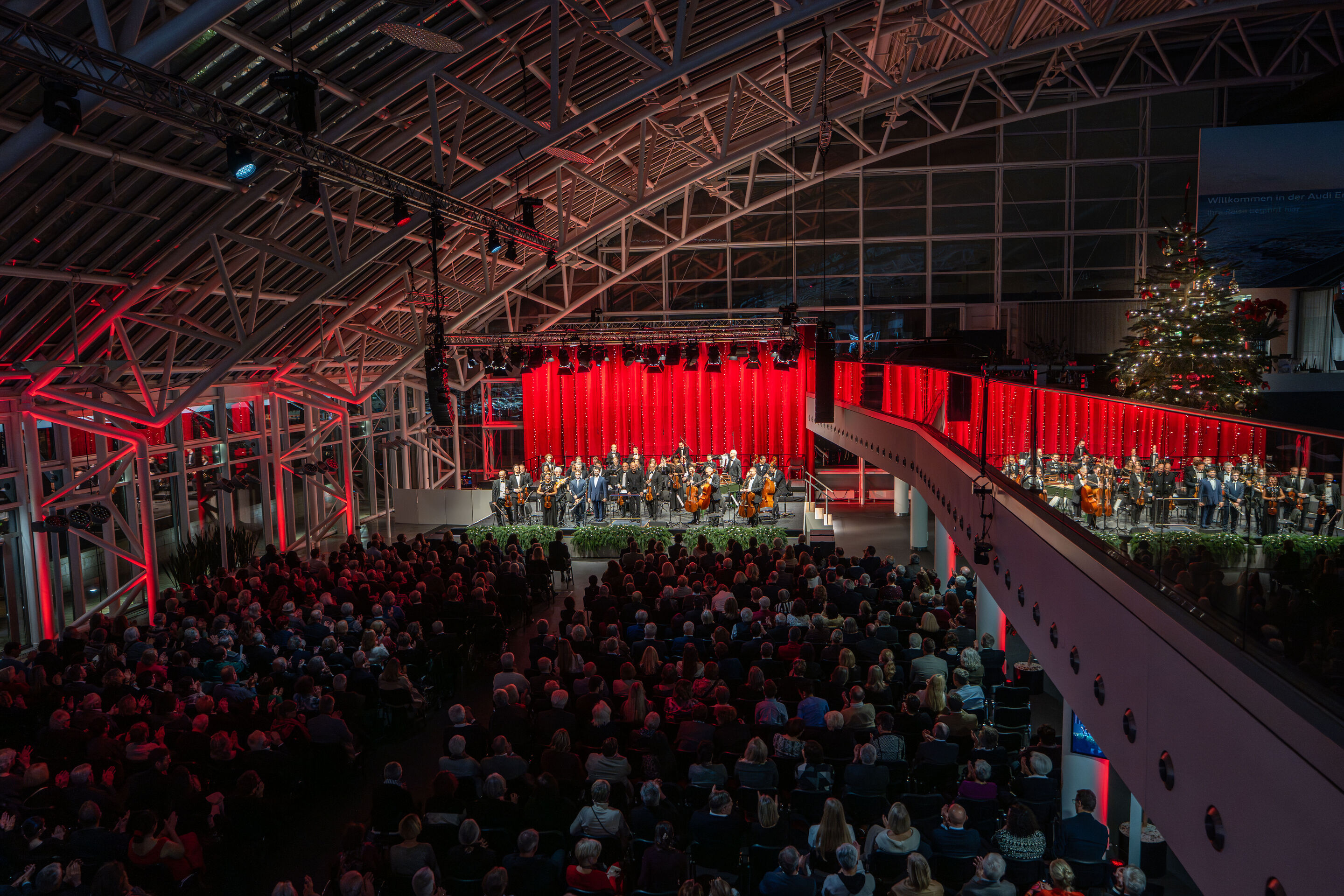 Audi Weihnachtskonzert 2025 - Trompeter Robin Paillet, Vokalist Lukas Enoch Lemcke (Bass) und Dirigent Ariel Zuckermann (v. l.) gemeinsam mit der Kammerphilharmonie Ingolstadt beim Audi Weihnachtskonzert am 12.12.2025 im Audi Forum Ingolstadt