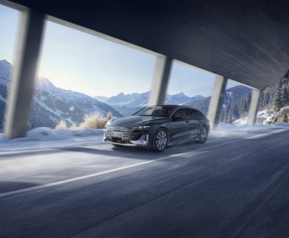 Audi S6 Avant e-tron - Audi S6 e-tron durchfährt vor verschneiter Bergkulisse eine Galerie.