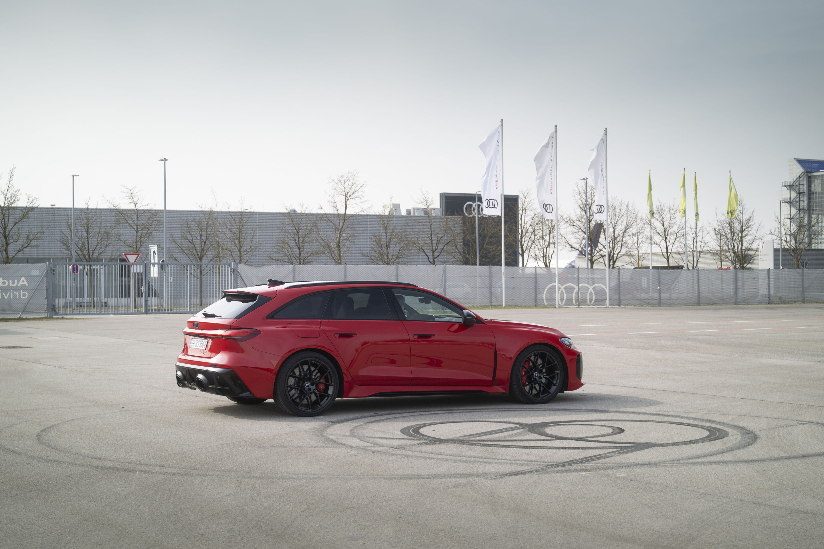 Audi RS 5 Avant - The Progressive red Audi RS 5 Avant during a dynamic circular maneuver – precise power distribution through quattro with electromechanical torque control.