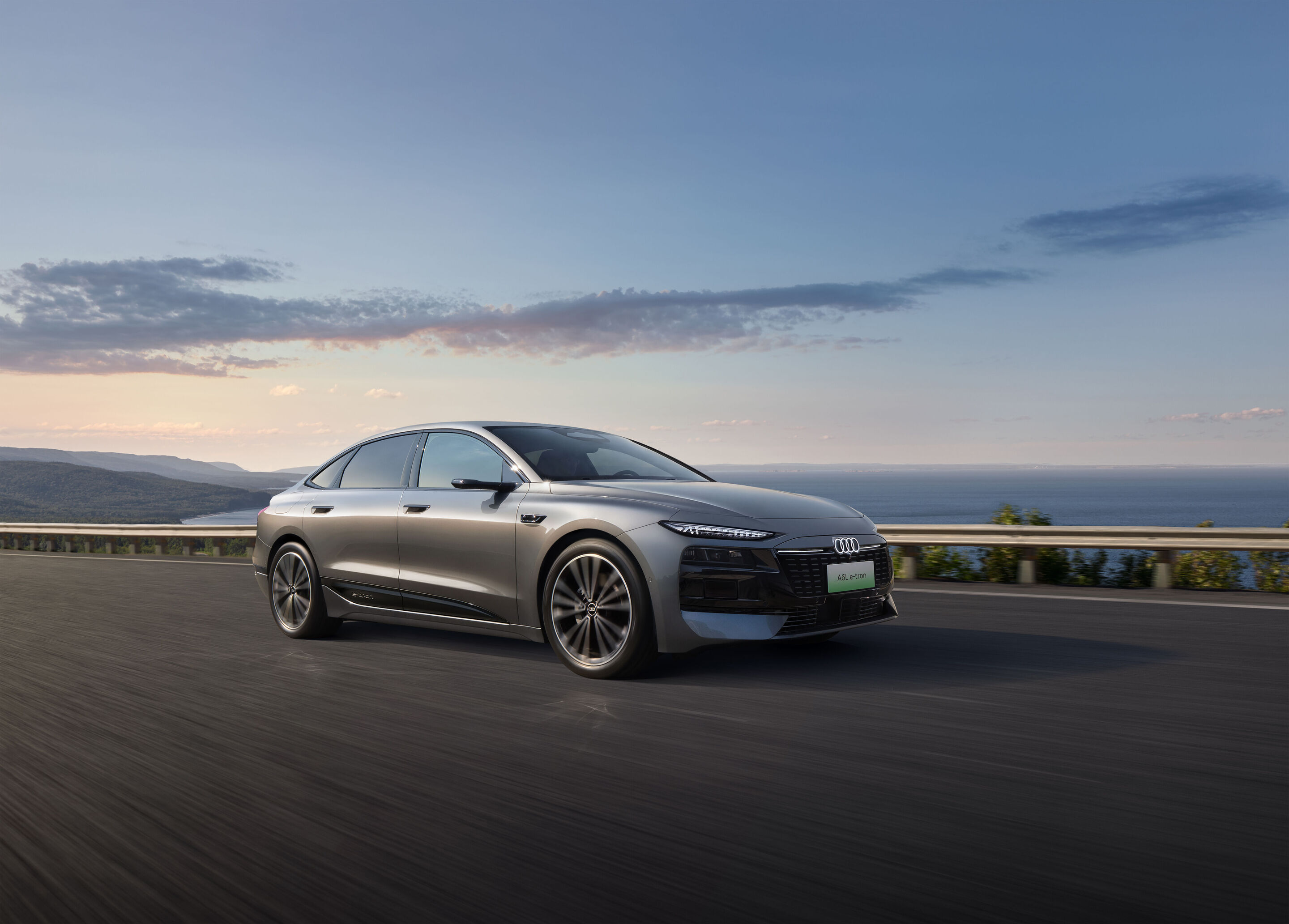 Audi at Auto China 2026 - Audi A6L e-tron, outdoor dynamic shot, exterior, three-quarter front view on a coastal road