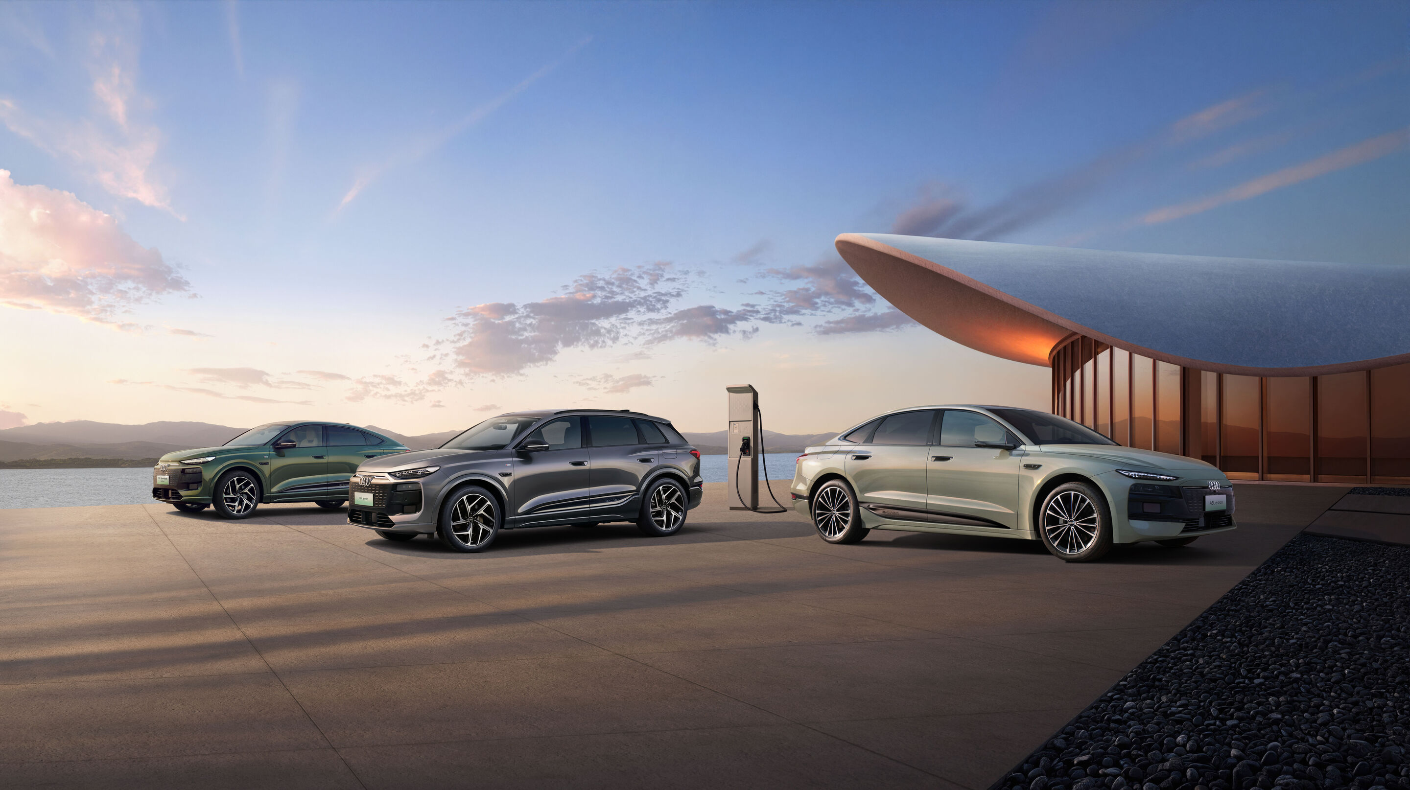 Audi at Auto China 2026 - Audi Q6L Sportback e-tron, Audi Q6L e-tron and Audi A6L, outdoor static shot, exterior, three-quarter front views with charging infrastructure as the focal point, in front of modern architecture