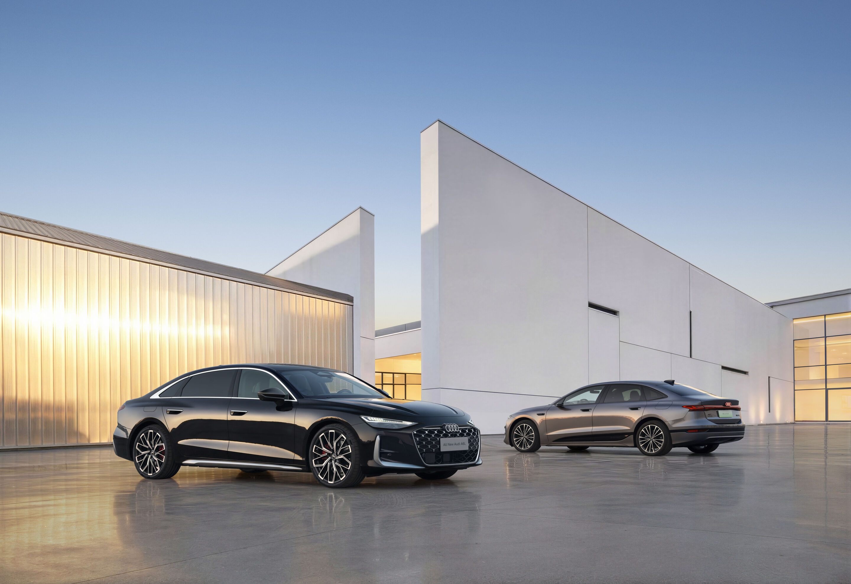 Audi at Auto China 2026 - From left in the image: Audi A6L, Audi A6L e-tron, outdoor static shot, exterior, each shown in three-quarter front and side view, in front of modern architecture