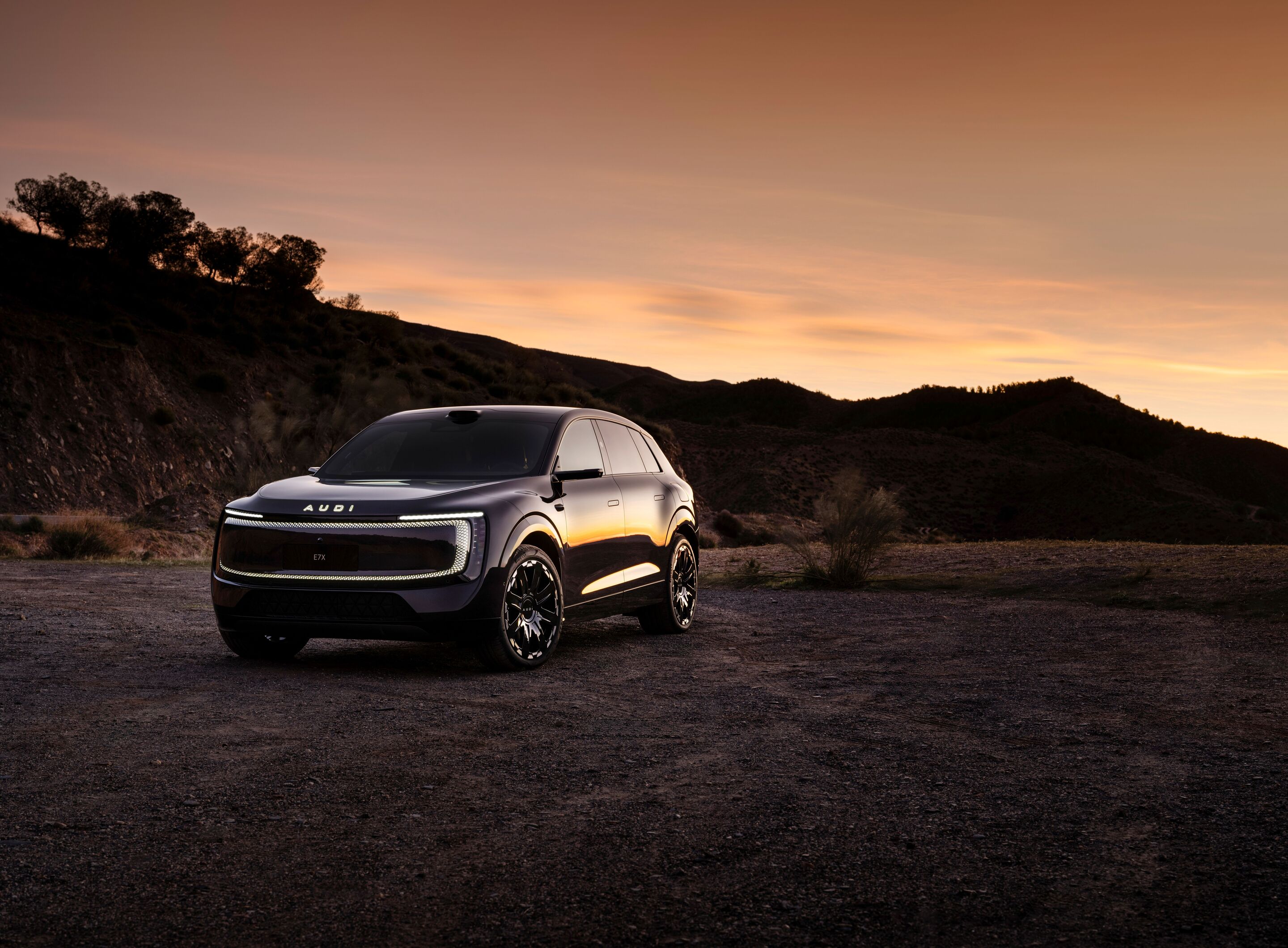 Audi at Auto China 2026 - Audi E7X, outdoor static shot, exterior, three-quarter front view set against a mountainous landscape at dusk
