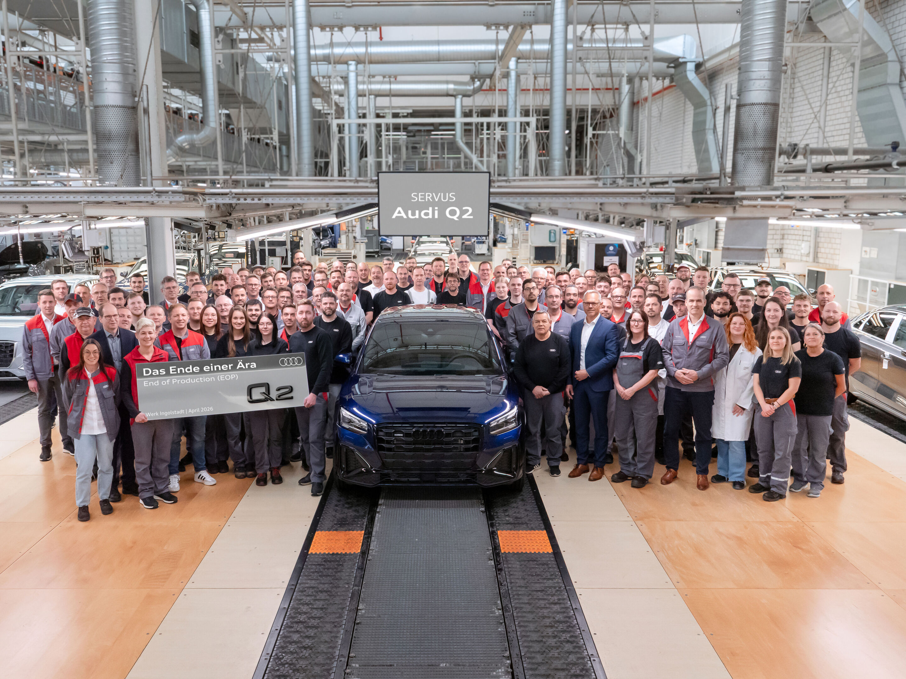 Audi stärkt Produktionsnetzwerk - Audi Beschäftigte versammeln sich in der Montage am Standort Ingolstadt für ein Gruppenbild mit dem Audi Q2. Die Fertigung des Modells endet im April 2026.