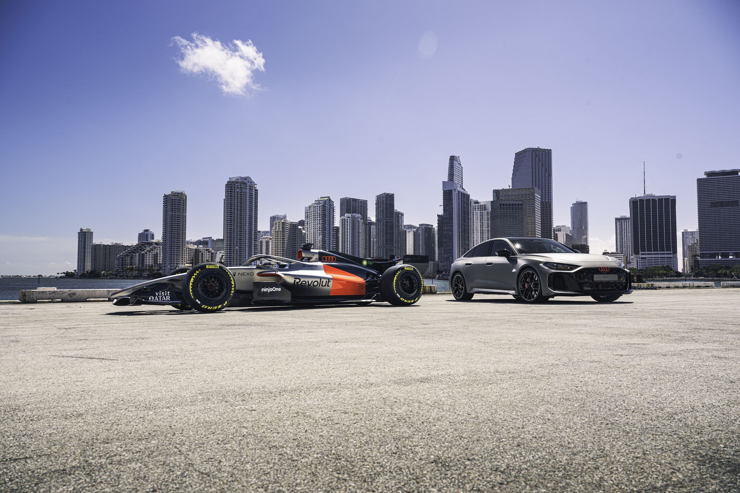 Audi RS 5: Debut as hot-lap car at Formula 1 - The Audi RS 5 next to the Audi R26 in front of the skyline of Miami. The RS 5 makes its debut at the Formula 1 Miami Grand Prix as a car for the F1® Pirelli Hot Laps