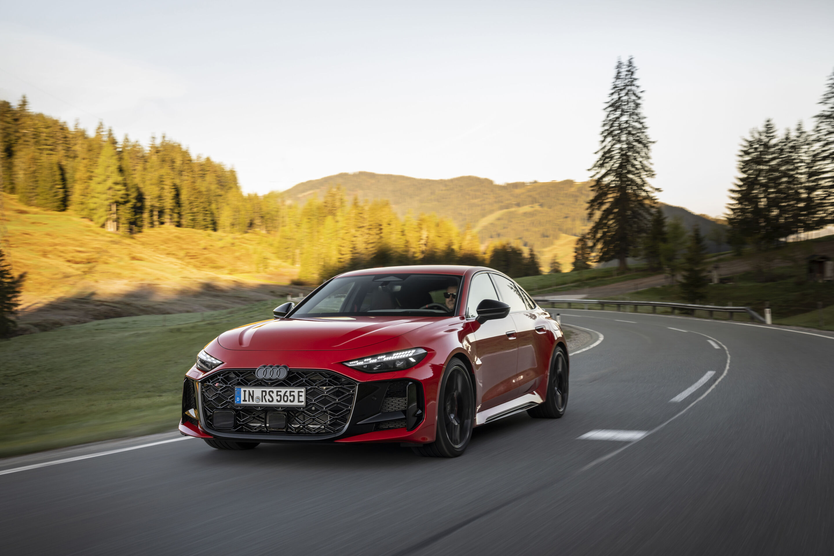 Audi RS 5 Sedan - Audi RS 5 Sedan in Progressive red, outdoor driving shot, exterior, front view on a winding country road.