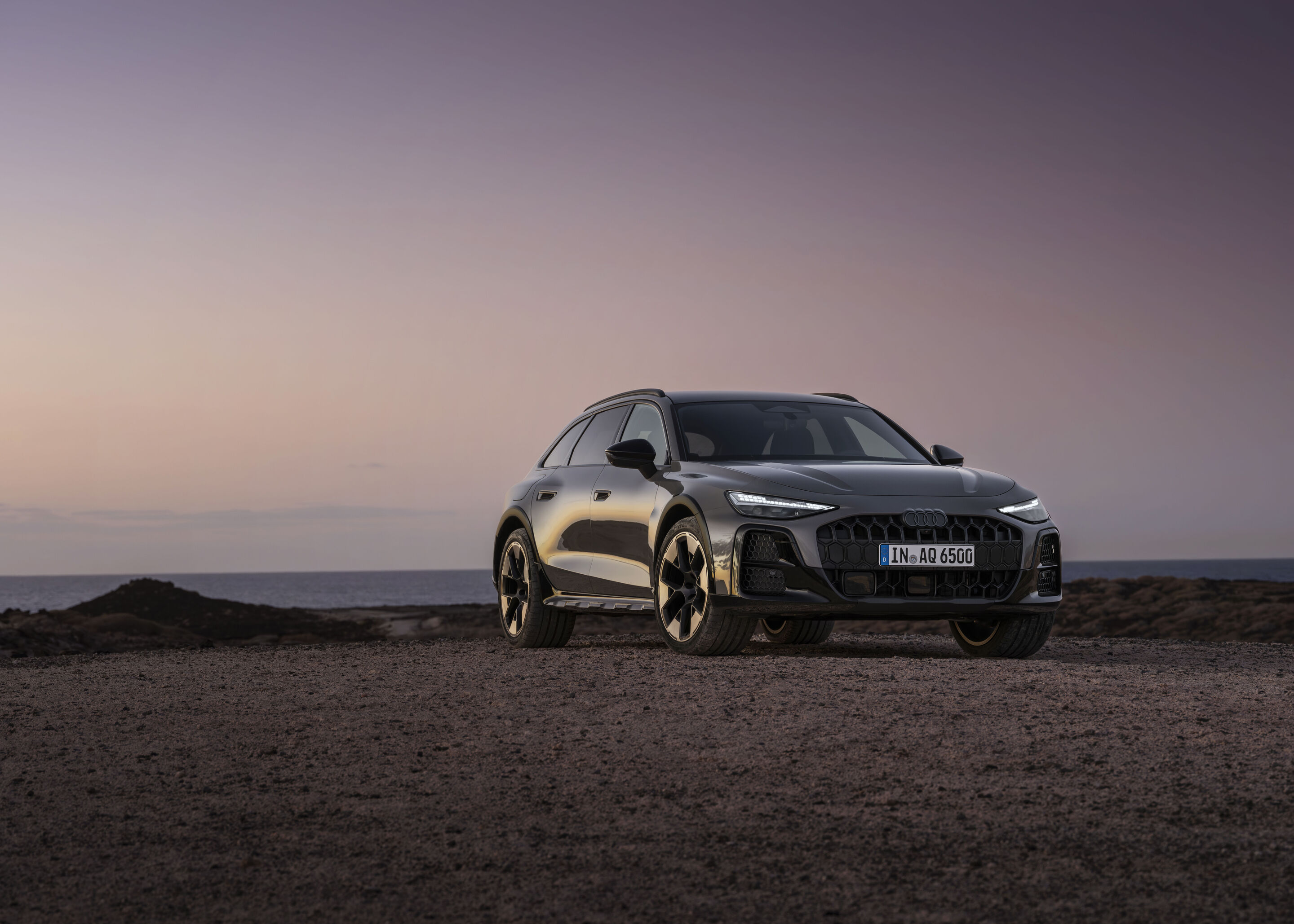 Audi A6 allroad quattro - ¾ Front view of the Audi A6 allroad (plateau grey metallic) against a calm sea horizon at dusk.