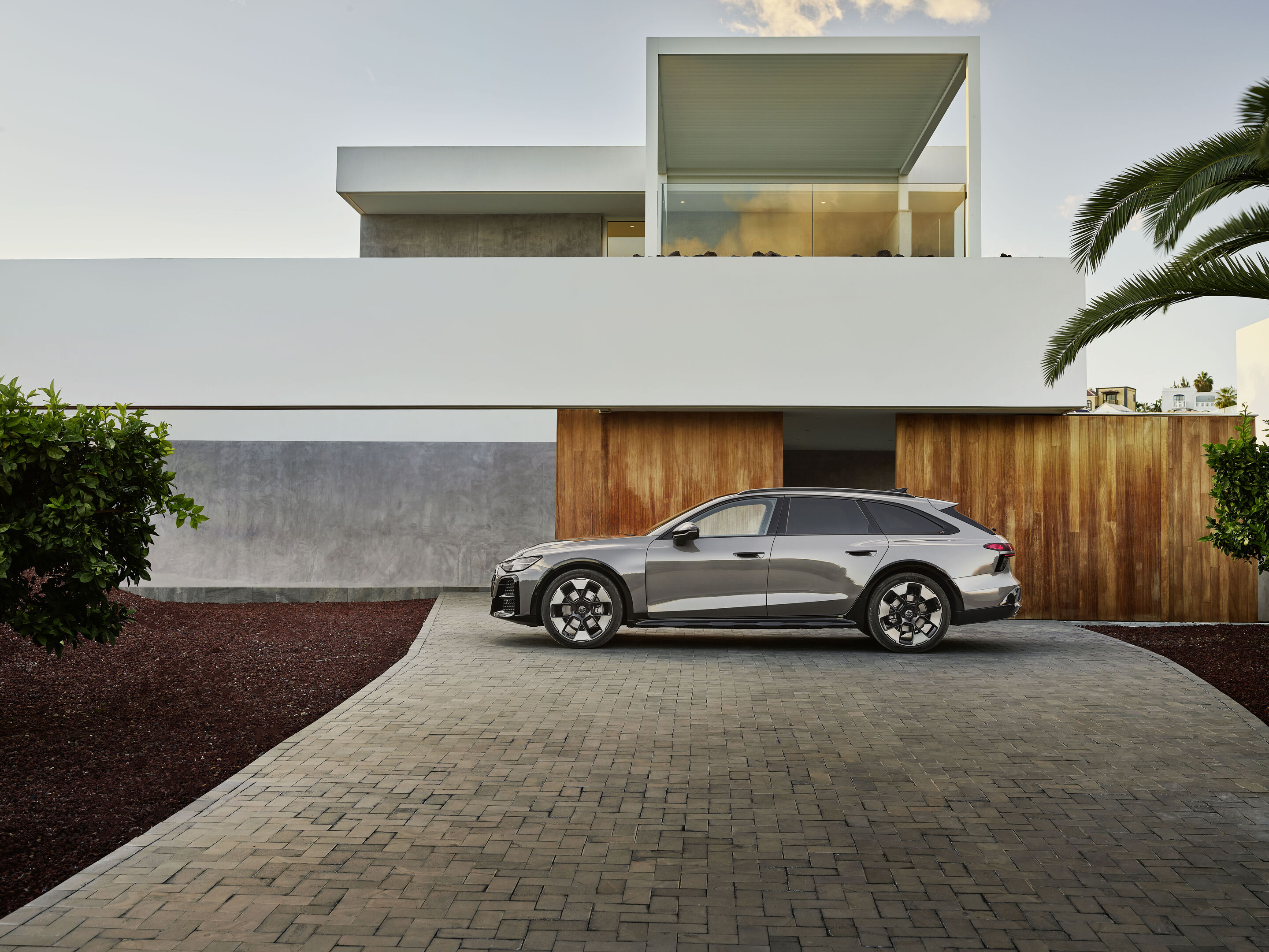 Audi A6 allroad quattro - Side view of Audi A6 allroad (plateau grey metallic) in front of modern architecture (static shot)