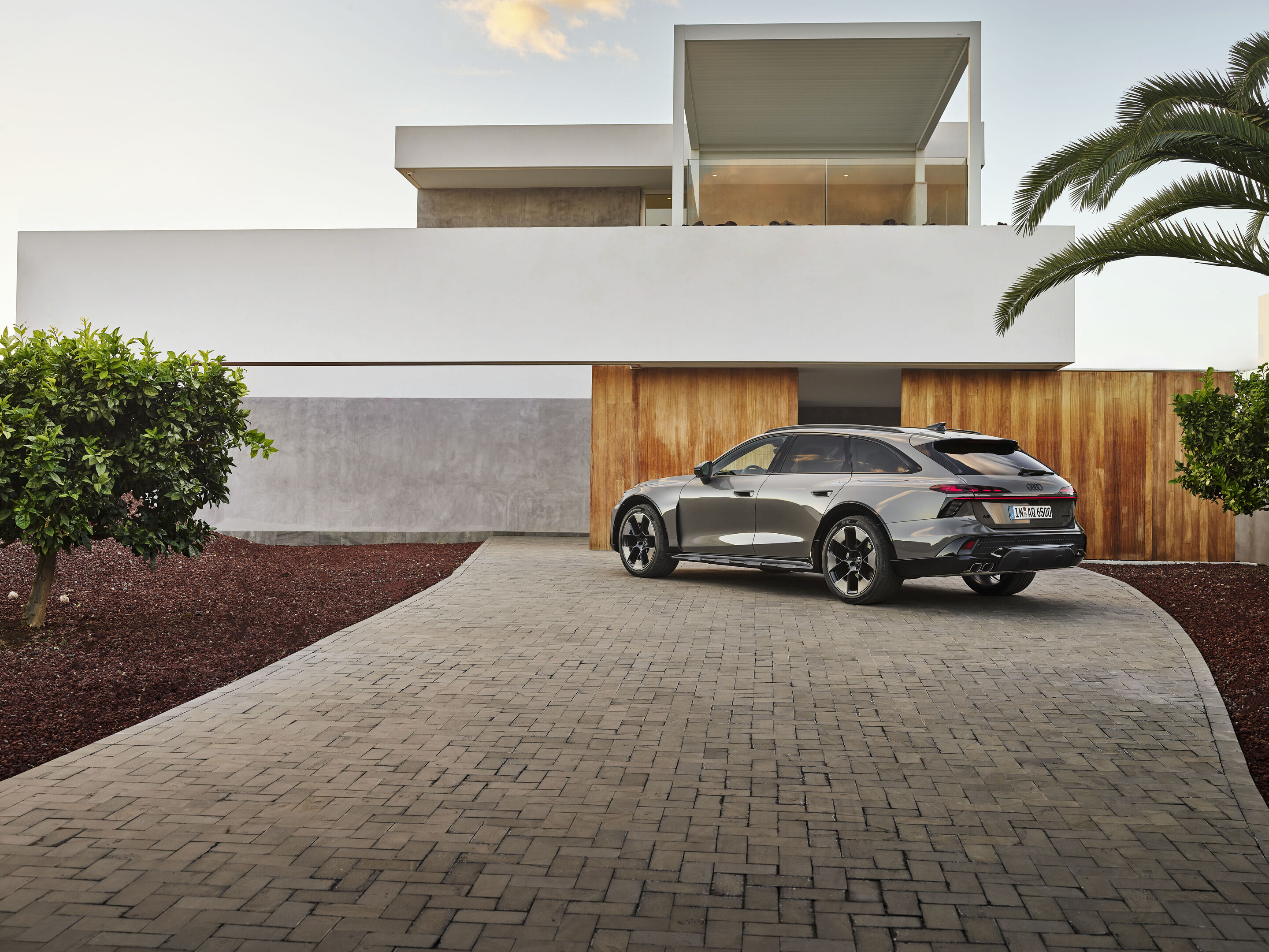 Audi A6 allroad quattro - Audi A6 allroad (plateau grey metallic) rear view in front of modern architecture (static shot).