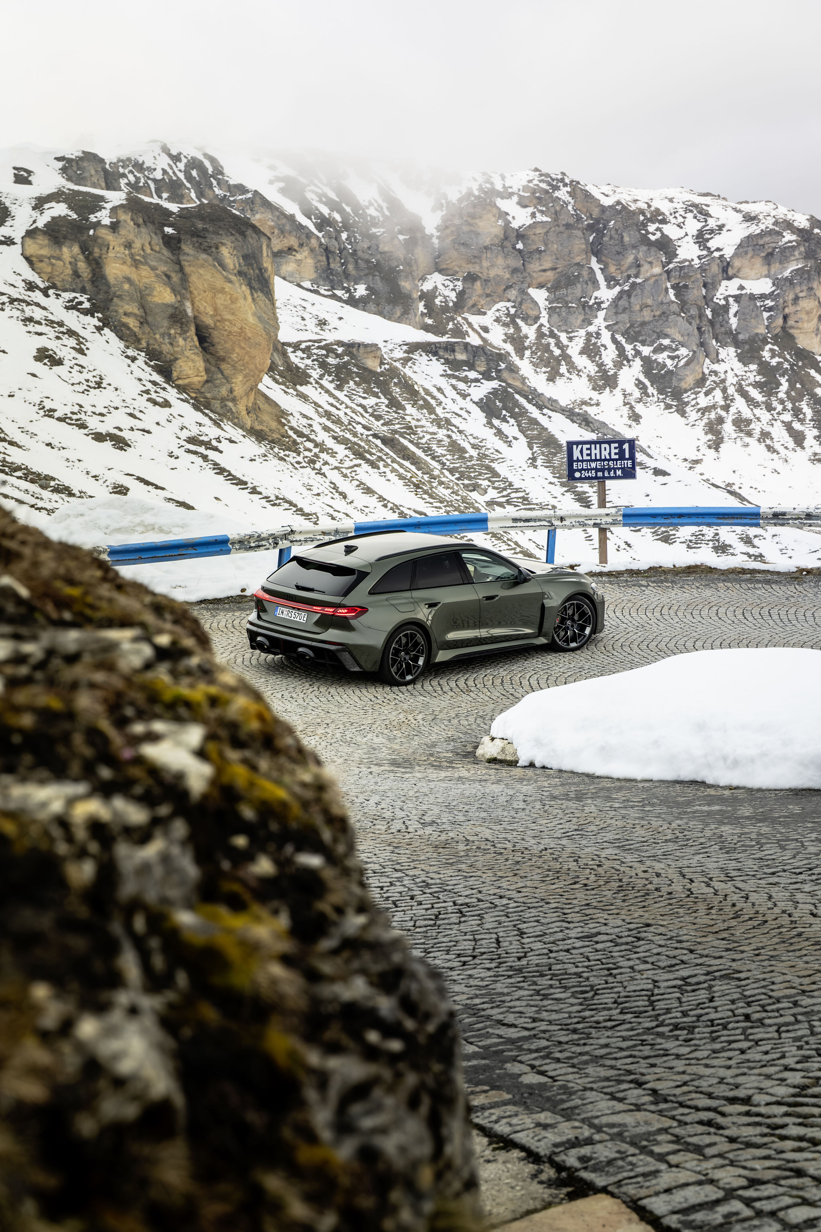 Audi RS 5 Avant - Audi RS 5 Avant in Bedfordgrün, Outdoor-Fahraufnahme, Exterieur, Heckansicht auf kurvenreicher, hochalpiner Straße.