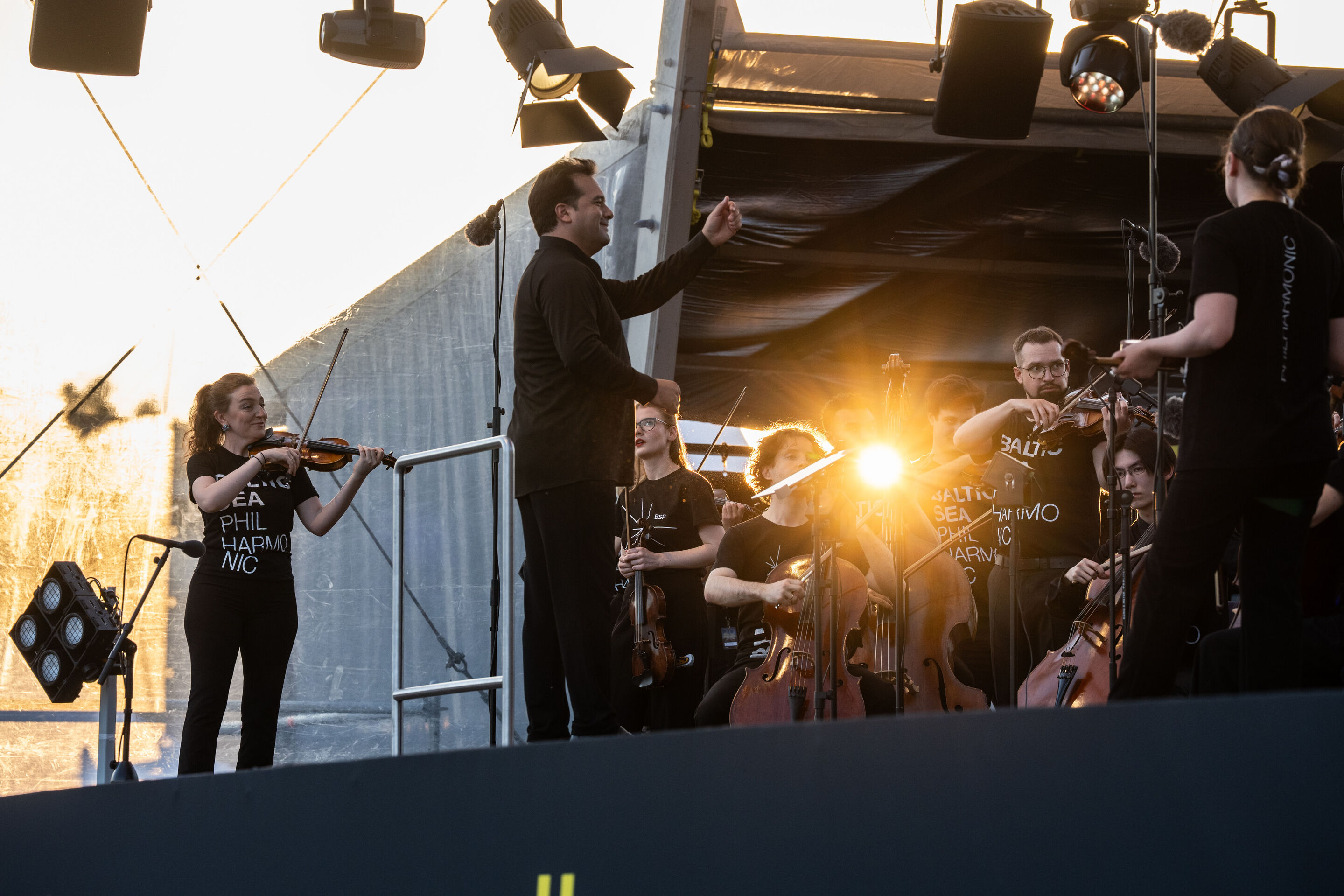 Baltic Sea Philharmonic performing at the classical open-air concert in Klenzepark - Conductor Robert Treviño leads the Baltic Sea Philharmonic at the 2026 Classical Open-Air Concert in Klenzepark, while the musicians perform with their instruments on...